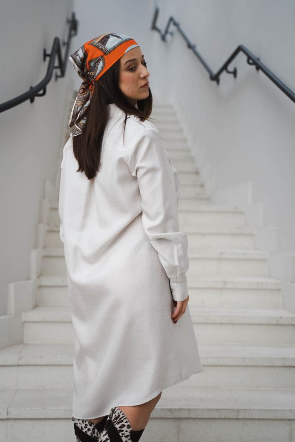 młoda kobieta ubrana w białą sukienkę koszulowa Bellfama na tle białych schodów